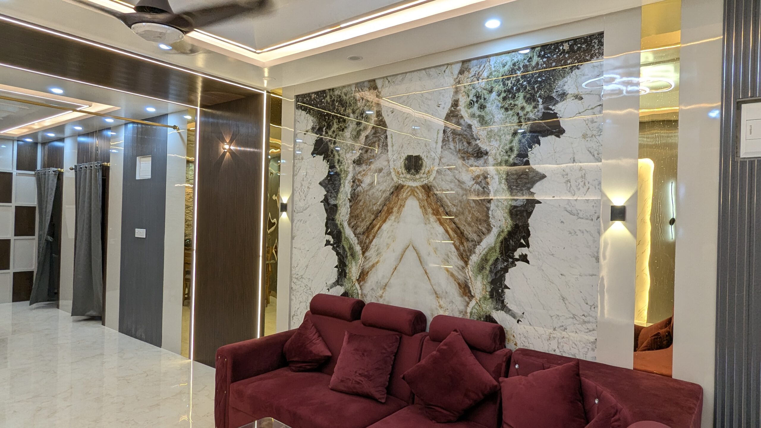 Elegant living room interior with tiles on wall, balanced lighting and functional furniture layout designed by Interior Bee in Patna.