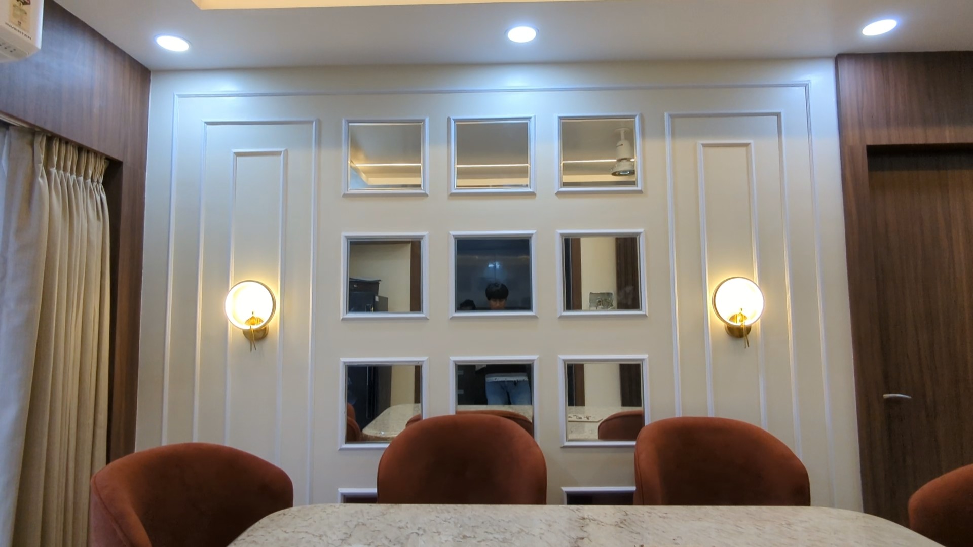 Elegant dining area with moulding and mirror on wall designed by Interior Bee in Patna.